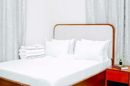a white bed with white sheets and pillows at Sastar Homes in Iringa