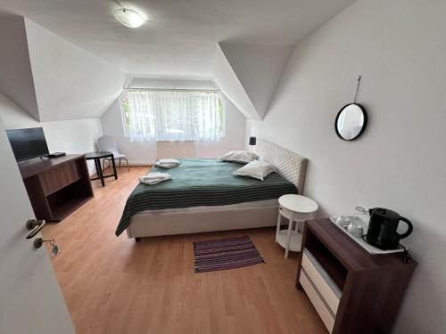 a bedroom with a bed and a desk and a television at Motel Valea Zanelor in Covasna