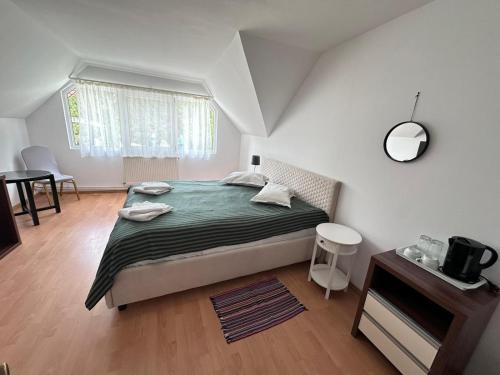 a bedroom with a bed and a table and a window at Motel Valea Zanelor in Covasna