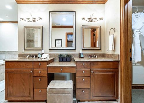 a bathroom with two sinks and two mirrors at 323 Beaver Creek Lodge in Avon