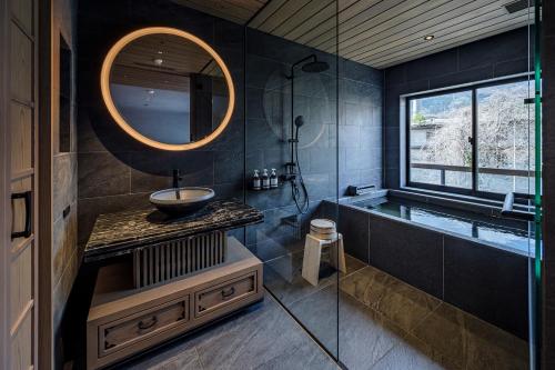 a bathroom with a sink and a tub and a mirror at Zazan minakami in Minakami