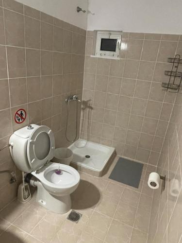 a bathroom with a toilet and a shower and a sink at Maria's Studios Rent Peplos in Péplos