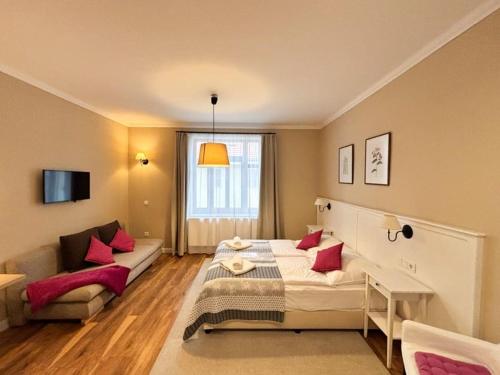 a hotel room with a bed and a couch at Erhardt Superior Rooms in Sopron
