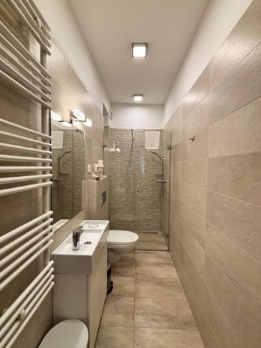 a bathroom with a sink and a toilet and a shower at Erhardt Superior Rooms in Sopron