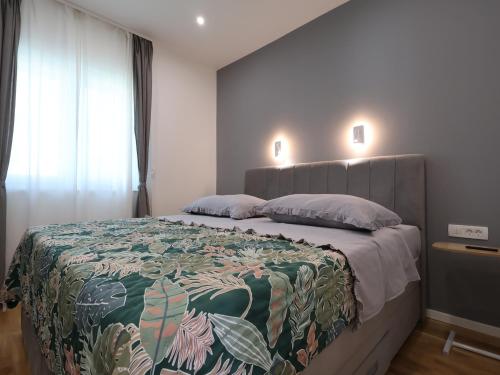 a bedroom with a large bed with a colorful blanket at Airport Split in Kastel Stafilic