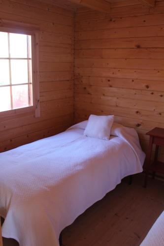 a bedroom with a bed in a log cabin at Finca el enebro in Valdemorillo