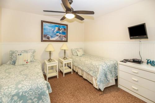 a bedroom with two beds and a ceiling fan at G218 - Palms Away in Oceanside