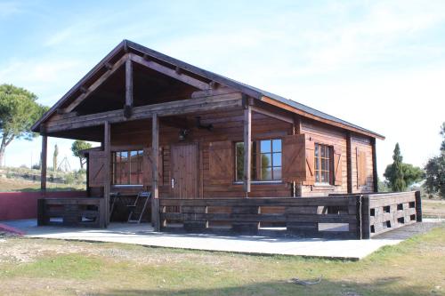 a small wooden cabin with a large window at Finca el enebro in Valdemorillo