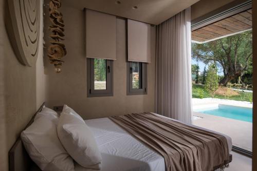 a bedroom with a bed and a window with a swimming pool at Domus Gaia Suites in Nikiti
