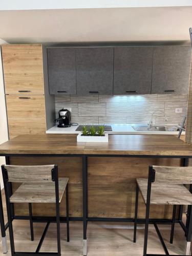 a kitchen with a large wooden counter with two chairs at Sa Domitta due Alghero in Alghero