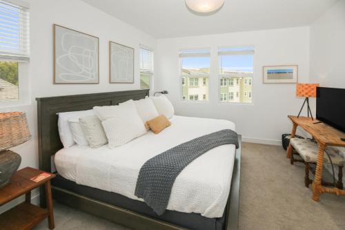 a bedroom with a bed with white sheets and pillows at Sea Glass Villa in Oceanside