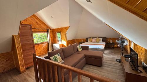 a living room with a couch and a bed at Digwa Beach Chalet in La Digue