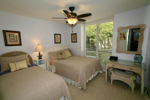 a bedroom with two beds and a ceiling fan at D2 - Breakwater Bungalow in Oceanside