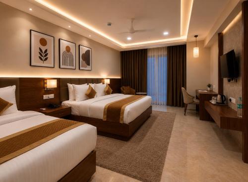 a hotel room with two beds and a desk at VITS Satyajeet Karad in Karād