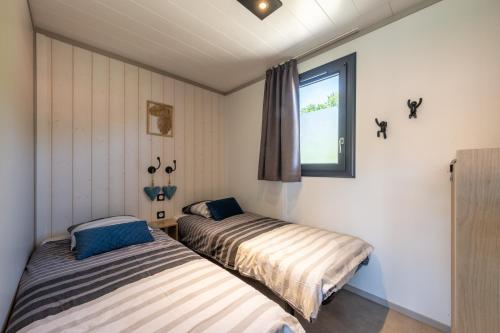 two beds in a room with a window at Chalet L'entékia - Billard et Spa in Corcieux