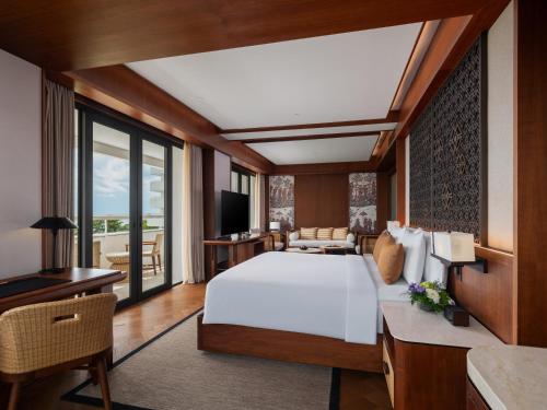 a bedroom with a large bed and a living room at Bali Beach Hotel in Sanur