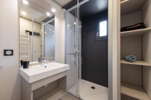 a bathroom with a sink and a shower at Chalet L'entékia - Billard et Spa in Corcieux