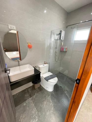 a bathroom with a toilet and a sink and a mirror at V house 1 in Ban Huai Yai