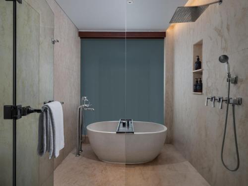 a bathroom with a bath tub and a shower at Bali Beach Hotel in Sanur