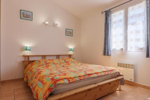 a bedroom with a bed with a colorful comforter at Le Micocoulier - La Fontinelle in Bessas