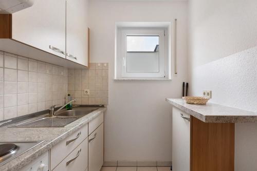 a white kitchen with a sink and a window at Apartment 45 in Bad Dürrheim