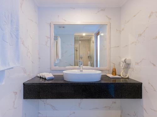 a bathroom with a sink and a mirror at Kaani Palm Beach in Maafushi