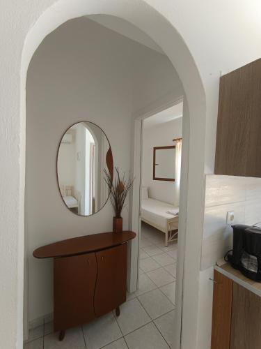 a bathroom with a mirror and a table with a sink at Maria Village in Vourvourou
