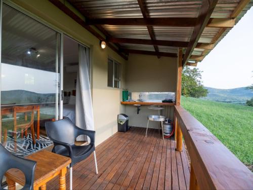a screened in porch with a table and chairs at Sunset Safari Camp at Hluhluwe Game Park in KwaNompondo