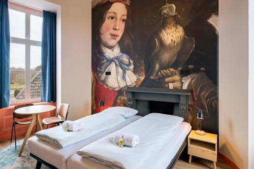 two beds in a room with a painting on the wall at Stayokay Hostel Domburg in Oostkapelle