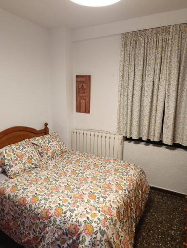 a bedroom with a bed and a window with curtains at Alojamiento Rural La Granja in La Cerradura
