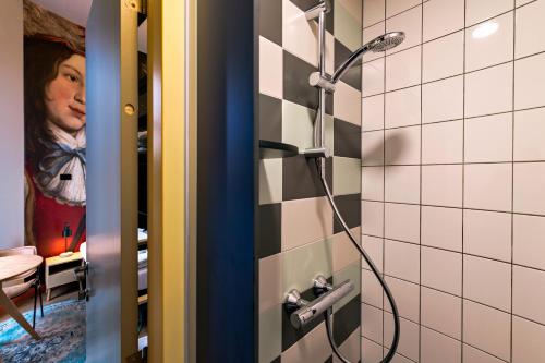a shower in a bathroom with a woman in the mirror at Stayokay Hostel Domburg in Oostkapelle