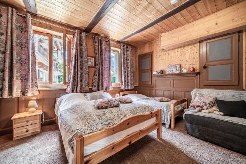 a bedroom with a bed and a couch at Maison De La Coutettaz in Morzine