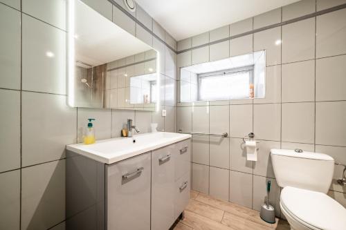 a white bathroom with a sink and a toilet at Chalet authentique en vallée verte in Bogève