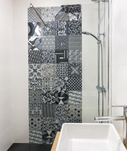 a bathroom with a black and white tile wall at Turyva Tarongers 1 - Modern 1-Bedroom Apartment Near the Beach, Costa del Azahar in Peniscola