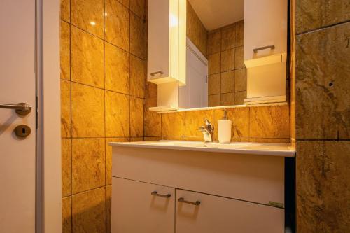 a bathroom with a sink and a mirror at G's Place in Prishtinë