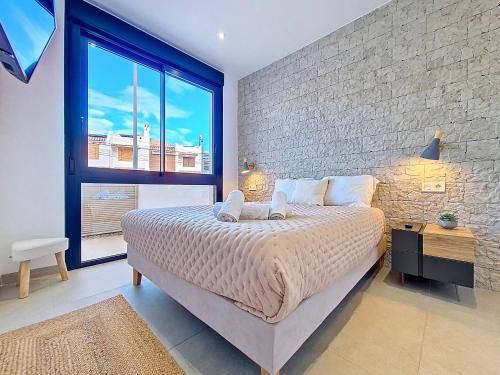 a bedroom with a large bed and a brick wall at La Llana Beach MDC - 8010 in Mar de Cristal