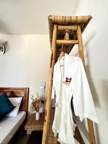 a white robe hanging on a ladder in a bedroom at The Sanctuary in El Nido