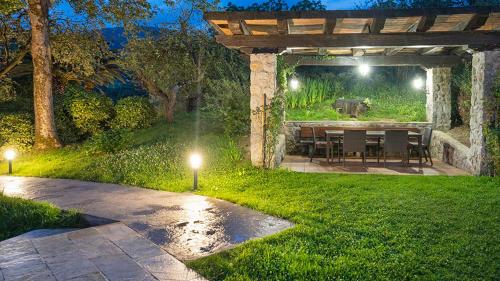 a patio with a table in a garden at night at Casa Rural Oroimena in Andoain