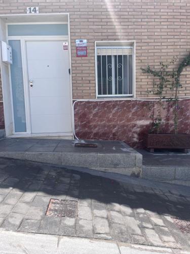 a white door on a brick building with a window at Cullera Mountain View in Cullera