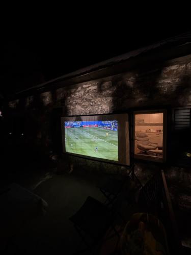 a television in a room with a soccer game at LOPATE mountain stone house in Lopate