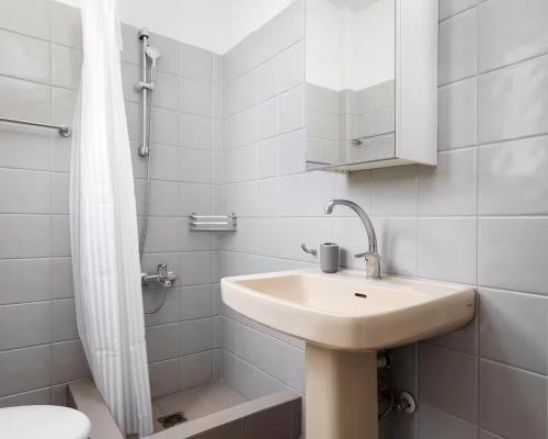 a white bathroom with a sink and a shower at Megusta Apartments Selianitika - Poolside Escape in Selianitika