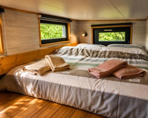 two beds in a room with two windows at Tiny house cosy au cœur des bois in Arsac-en-Velay
