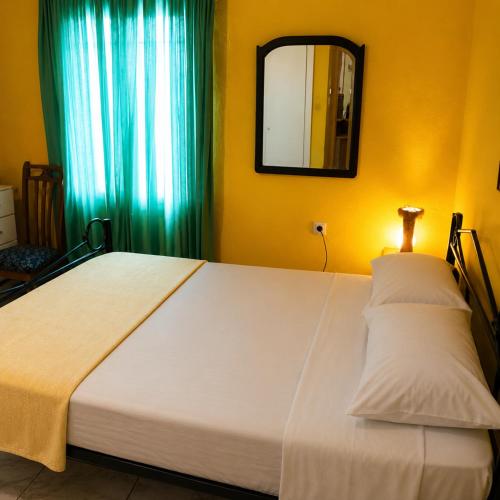 a large white bed in a room with a mirror at Julia Country Home 200m from the Beach in Nea Plagia