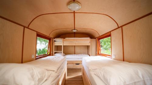two beds in a small room with two windows at Schloss Sigrön Zirkuswagen in Bad Wilsnack