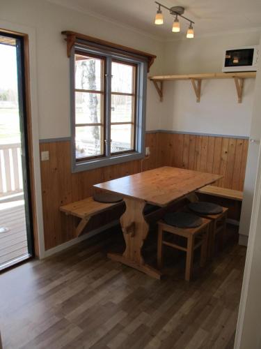 a dining room with a wooden table and benches at Klarälvens Camping in Stöllet