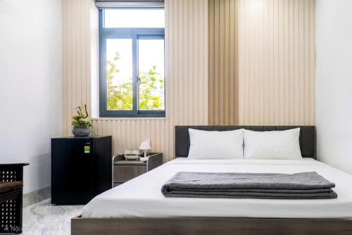 a bedroom with a large bed and a window at LUNA House in Can Tho