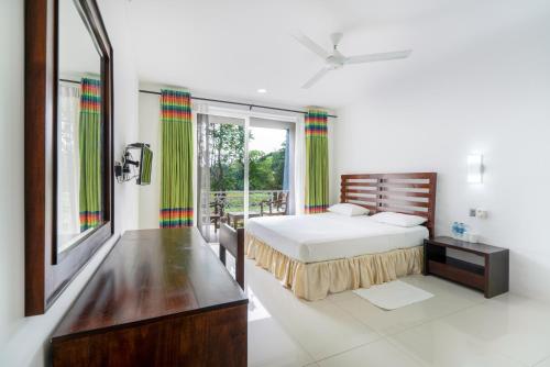 a bedroom with a bed and a large window at Lavendish Wild Safari in Wasgamuwa