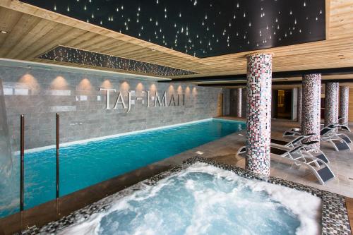 a swimming pool with a hot tub in a building at Hôtel Taj-I Mah by Les Etincelles in Arc 2000