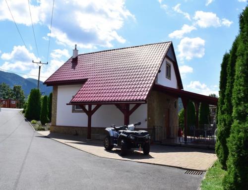 a car parked in front of a house at Apartmánový dom v Panoráma Parku in Nezbudská Lúčka