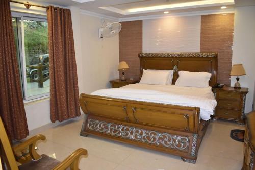 a bedroom with a large bed and a window at Redapple Rooms in Murree